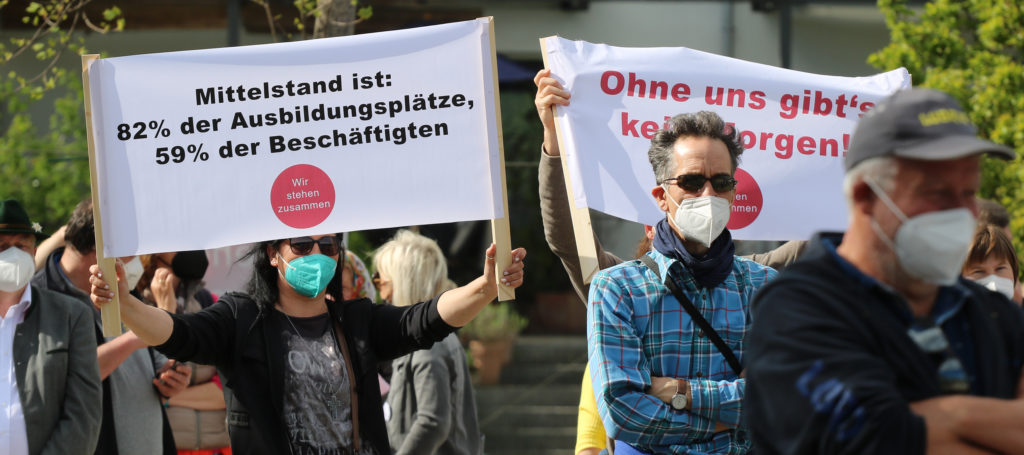 Transparente auf der Demonstration "Hand in Hand für den Mittelstand" der Unternehmer-Initiative "Wir stehen zusammen" am 30. April 2021 im Mangfallpark Rosenheim. Foto: Olaf Konstantin Krueger